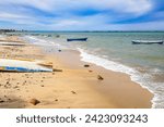 Mexican beach coastal landscape, rowboat on sand, others in waters of Sea of Cortez, horizon against blue sky with white clouds in background, sunny day in La Paz, Baja California Sur Mexico