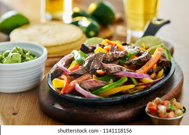 Mexican Beef Fajitas In Iron Skillet With Guacamole And Beer