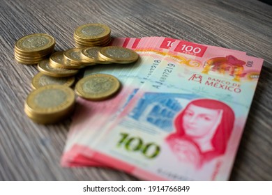 Mexican bill and coins with a wooden background