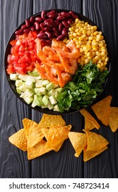 Mexican Burrito Bowl With Shrimp, Beans, Corn, Avocado And Herbs Closeup On The Table. Vertical Top View From Above
