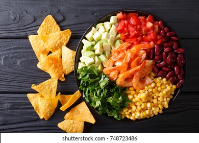 Mexican Burrito Bowl With Shrimp, Beans, Corn, Avocado And Herbs Closeup On The Table. Horizontal Top View From Above
