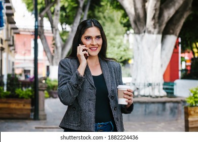 Mexican Business Woman Talking By Phone While She Is Walking In A Latin America City