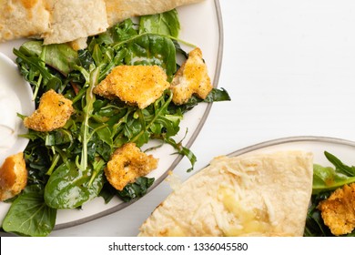 Mexican Cheese Chicken Quesadilla Served With Fresh Guacamole And Sour Cream On An A Mini Plate. Served With A Side Kale And Super Green Salad With Homemade Croutons. Table Top View 