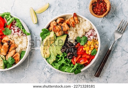 Mexican chicken burrito bowl with rice, beans, tomato, avocado,corn and lettuce.