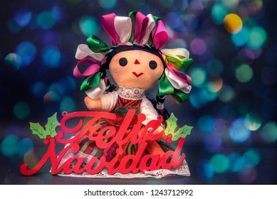 Mexican Christmas Doll With Colorful Sign And Ribbons In Bright Lights Background