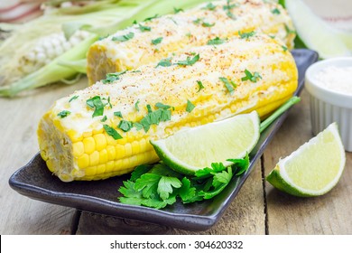 Mexican corn with butter, mayonnaise, parmesan, chili, cilantro, and lime