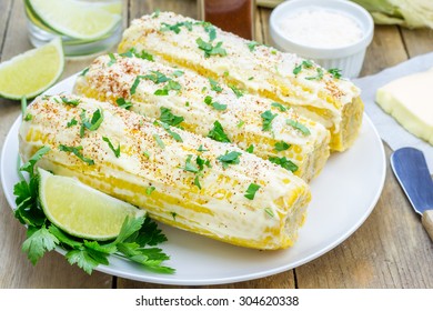 Mexican corn with butter, mayonnaise, parmesan, chili, cilantro, and lime