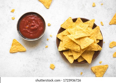 Mexican Corn Chips Nachos And Traditional Salsa Dip On White, Copy Space. Tortilla Or Nacho Chips With Tomato Hot Sauce For Snack.