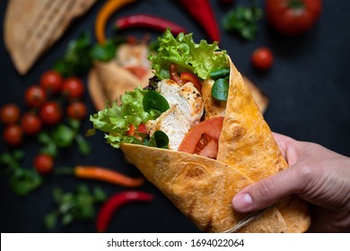 Mexican Corn Tortilla Wrap With Grilled Chicken And Fresh Vegetables. Dietary Healthy Dish. Close-up Female Hand Holding Tortilla Sandwich