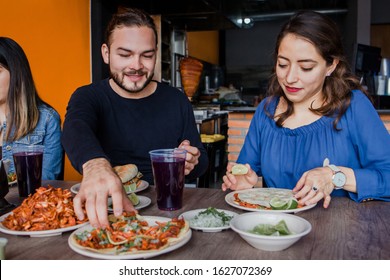 Mexican couple eating Tacos al Pastor in a Taqueria in Mexico