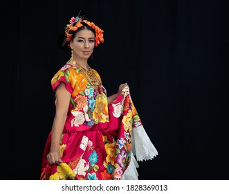 Mexican Dancer From Oaxaca Mexico, Wearing A Costume From The Region Of The Isthmus Of Tehuantepec, Dances In The Guelaguetza , With A Black Background And A Hand-embroidered