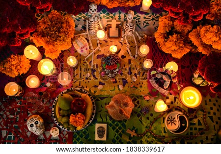 Mexican day of the dead altar at night in dim candlelight