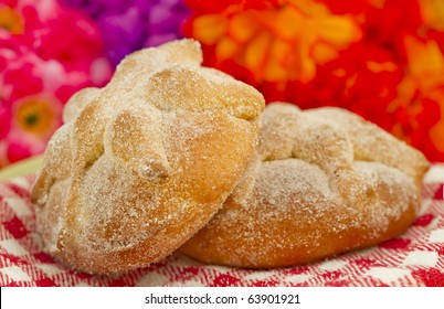 Mexican Day of the dead bread, Pan de Muerto, with flowery background.