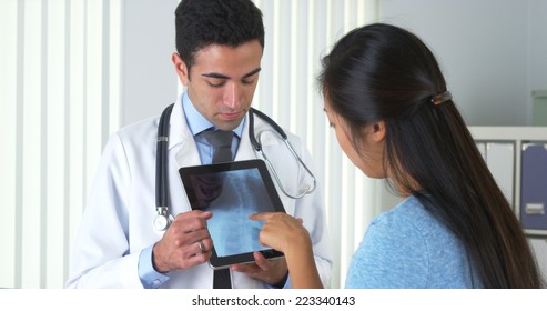 Mexican Doctor Talking With Chinese Patient About Xray