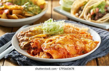 Mexican Enchilada Platter With Red Sauce, Refreied Beans And Rice