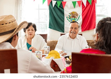 Mexican family celebrate together the day of the independence of Mexico with a traditional dinner. Grandparents, mother and son eat traditional Mexican dishes together during a family reunion. - Powered by Shutterstock