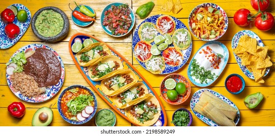 Mexican festive food for independence day - independencia chiles en nogada, tacos al pastor, chalupas pozole, tamales, chicken with mole poblano sauce. Yellow background - Shutterstock ID 2198589249