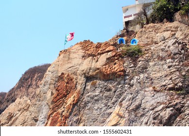 Mexican Flag And Altars Of The Virgin Mary On Top Of Famous Diving Cliff La Quebrada, Acapulco, Mexico