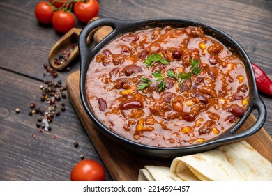 Mexican food chile con carne dish on a wooden backdrop. Bean and corn soup, red bean stew