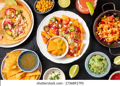 Mexican Food, A Flat Lay Overhead Shot On A Dark Background. Nachos, Tacos, Guacamole, Shrimps, Paloma Cocktails, Shot From Above