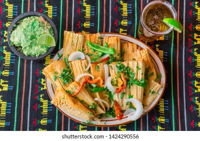 Mexican Food. Plate Of Tamales With Herbs And Chilies On Top. Mexican Table Cloth On The Background.