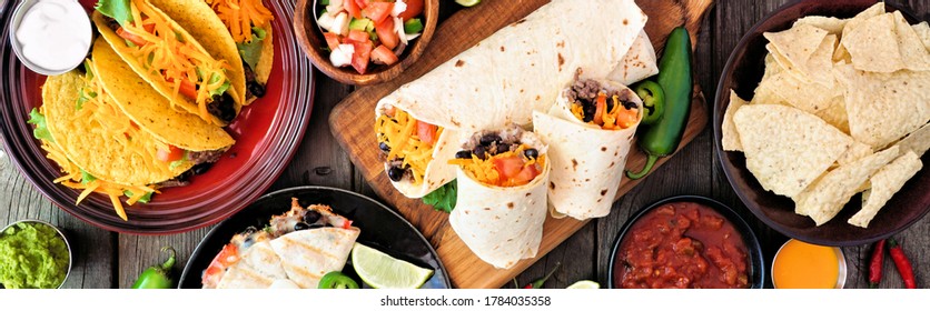 Mexican Food Table Scene Banner. Top Down View Over A Dark Wood Background. Tacos, Burritos, Quesadilla And Nachos.