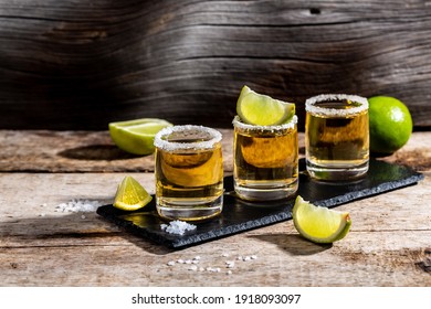 Mexican Gold Tequila with lime and salt on rustic wooden background. Alcoholic drink concept. Mexican national drink copyspace.