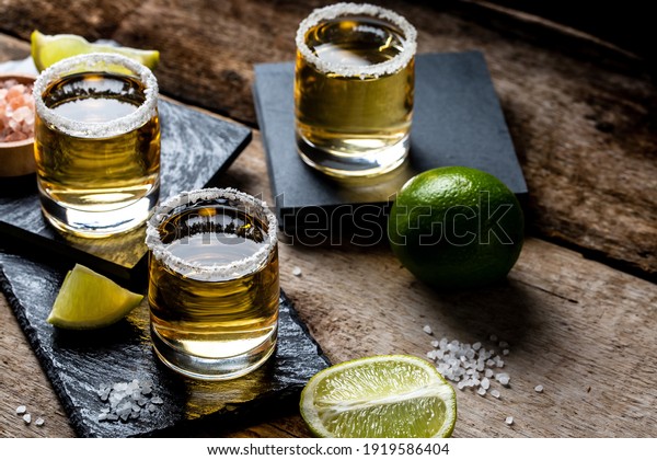 Mexican Gold Tequila with lime and\
salt on stone background. concept luxury drink. Alcoholic\
drink