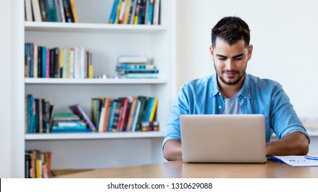 Mexican Hipster Man Working With Computer Indoor At Desk At Home 