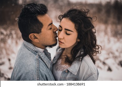 Mexican Hispanic Man In Denim Jacket Oversized And Woman Are Kissing Hugging Laughing. Groom And Bride Wedding Love Couple In Winter In Snow. Fashionable Stylish Party Wedding Wear 2021