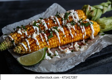 mexican hot grilled corn cobs elote, dark photo