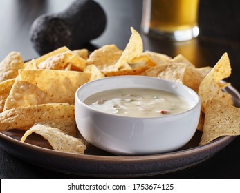 mexican hot queso blanco cheese dip with corn tortilla chips on plate