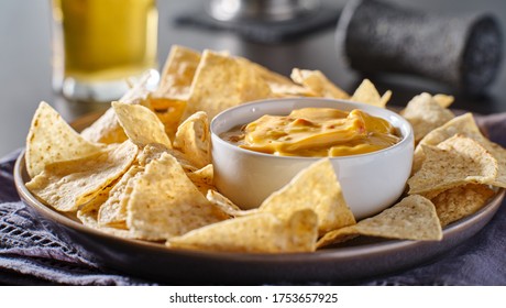 mexican hot queso cheese dip with corn tortilla chips on plate
