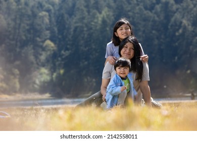 Mexican mother with daughter and son hugging outdoors