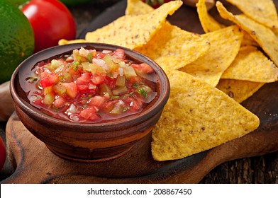 Mexican Nacho Chips And Salsa Dip In Bowl On Wooden Background