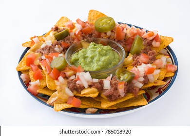 Mexican Nachos With Beef, Guacamole, Cheese Sauce, Peppers, Tomato And Onion In Plate Isolated On White Background