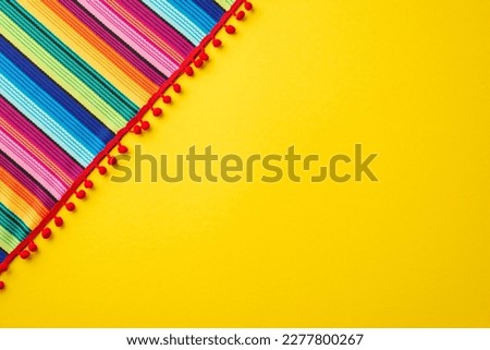 Mexican national holiday concept. Top view photo of colorful striped serape on isolated bright yellow background with empty space