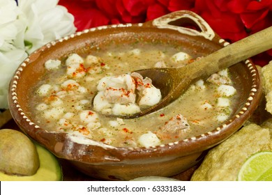 Mexican Pozole soup made with white large corn, pork, chicken, oregano and chili. With sideinngs like avocado, pork grinds, raw onion and lime.