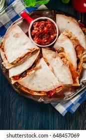 Mexican Quesadilla with chicken, sausage chorizo and red pepper served with salsa. Top view