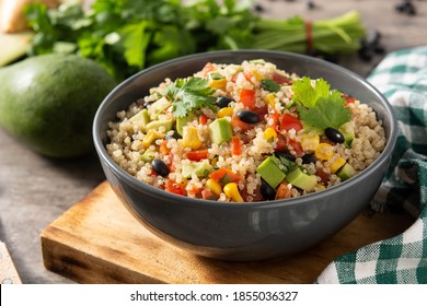 Mexican salad with quinoa in bowl on wooden table