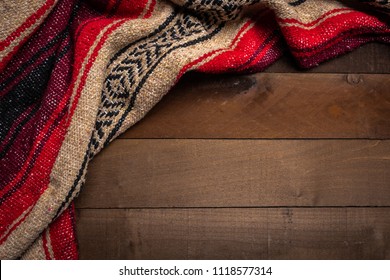 A Mexican Serape Blanket On A Wooden Plank Background