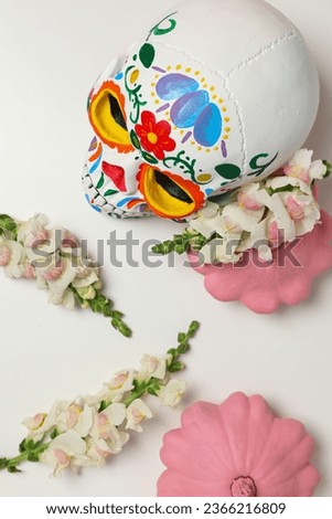 Mexican skull, zucchini and flowers on white background, top view