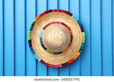 Mexican sombrero hat on blue wooden surface, top view