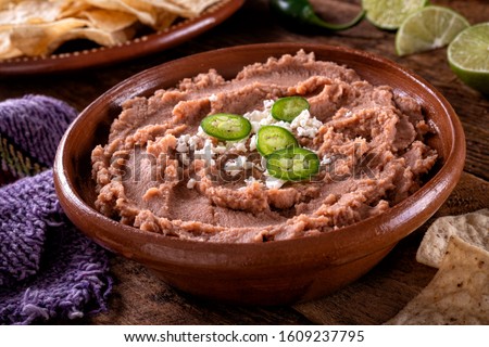 Mexican style refried beans with queso fresco and jalpeno pepper garnish. Foto stock © 