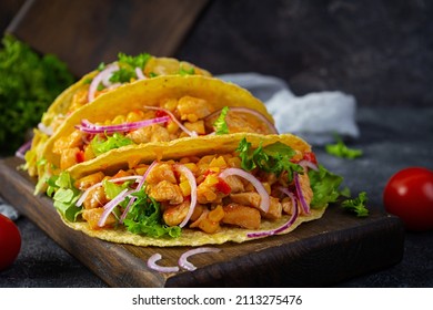 Mexican tacos with corn tortilla. Tortilla with chicken meat, corn, lettuce and onion