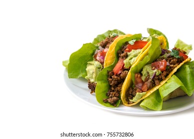 Mexican Tacos, Crunchy Corn Shells Stuffed With Fried Ground Beef, Tomato Salsa And Guacamole On A White Background With Copy Space, Selected Focus, Narrow Depth Of Field