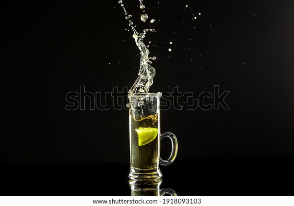 Mexican tequila\
with lime on black background. space for text. concept luxury\
drink. Alcoholic drink concept. Freeze motion, drops in liquid\
splash Mexican national\
drink.