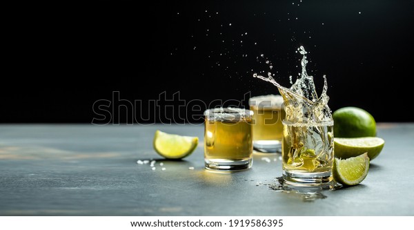 Mexican tequila\
with lime and salt on stone background. concept luxury drink.\
Alcoholic drink. Freeze motion, drops in liquid splash Mexican\
national drink. space for\
text.