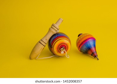 Mexican Toys From Wooden, Balero, Yoyo And Trompo In Mexico On A Yellow Background