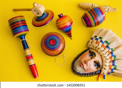 mexican toys from Wooden and mask, balero, yoyo and trompo in Mexico on a yellow background